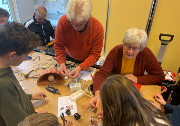 Ouderen en kinderen repareren samen spullen