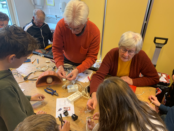 Ouderen en kinderen repareren samen spullen