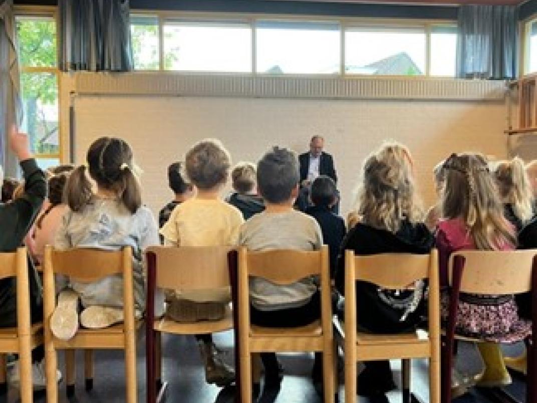 Groep kinderen en wethouder